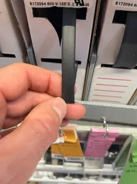 A hand holding the shrink tube