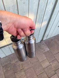 Two Klean Kanteen bottles held with one hand by using the handle on the sport cap of the bottles.