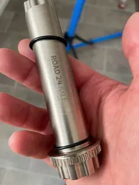 A hand holding the Rotor Road Crank Axle