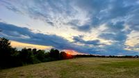 Sunset with a red sun and blue clouds.