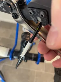 A hand holding the ParkTool HBT-1 while cutting a bake hose