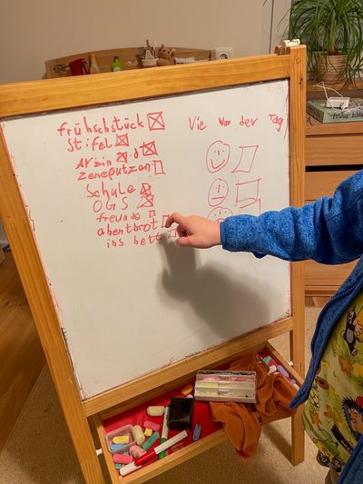 Emil points to his whiteboard, which contains a list of activities for the day.
