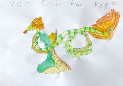 A snake-like dragon with a light green body and orange feathers.