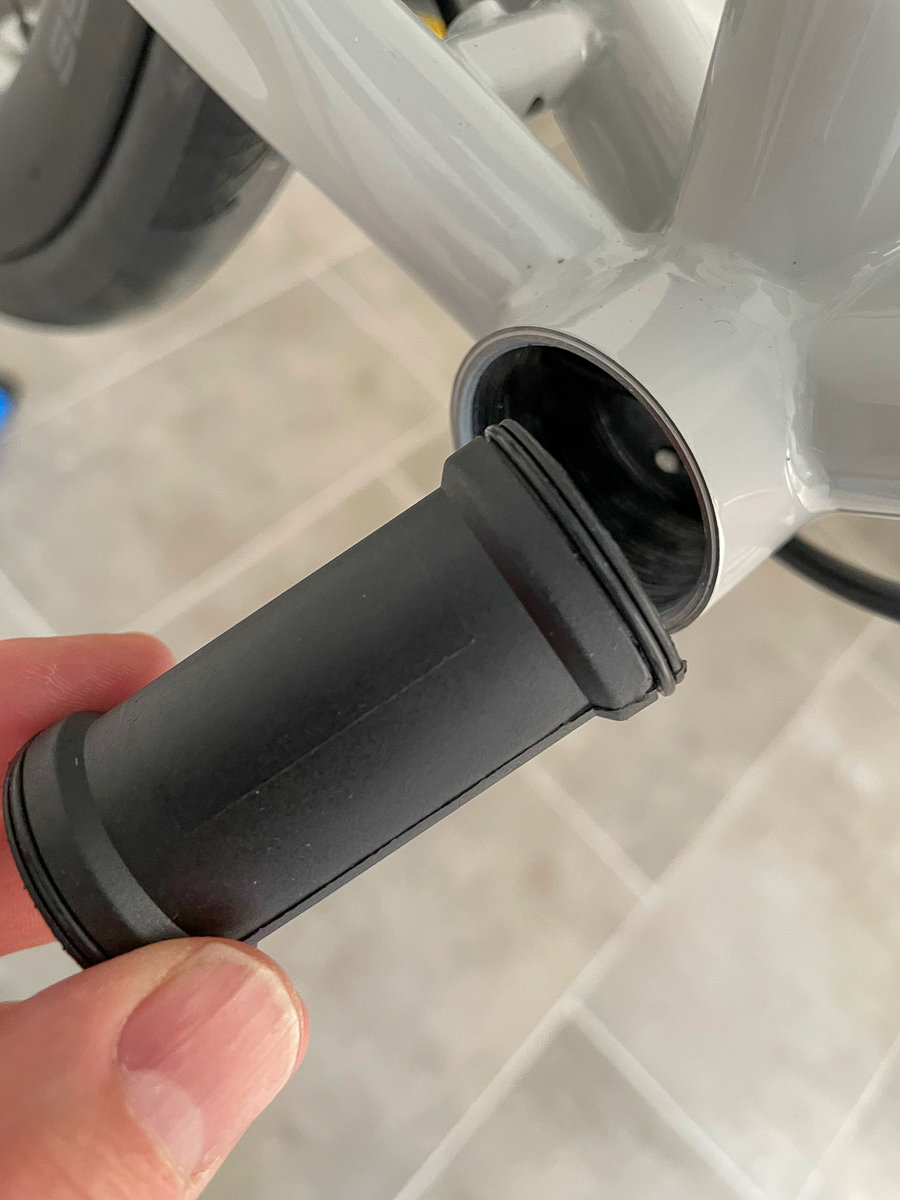 A hand holding the Rotor BB1 plastic cover aside of the bottom bracket shell
